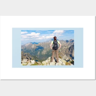 Woman with backpack standing on the edge, looking at mountains Posters and Art